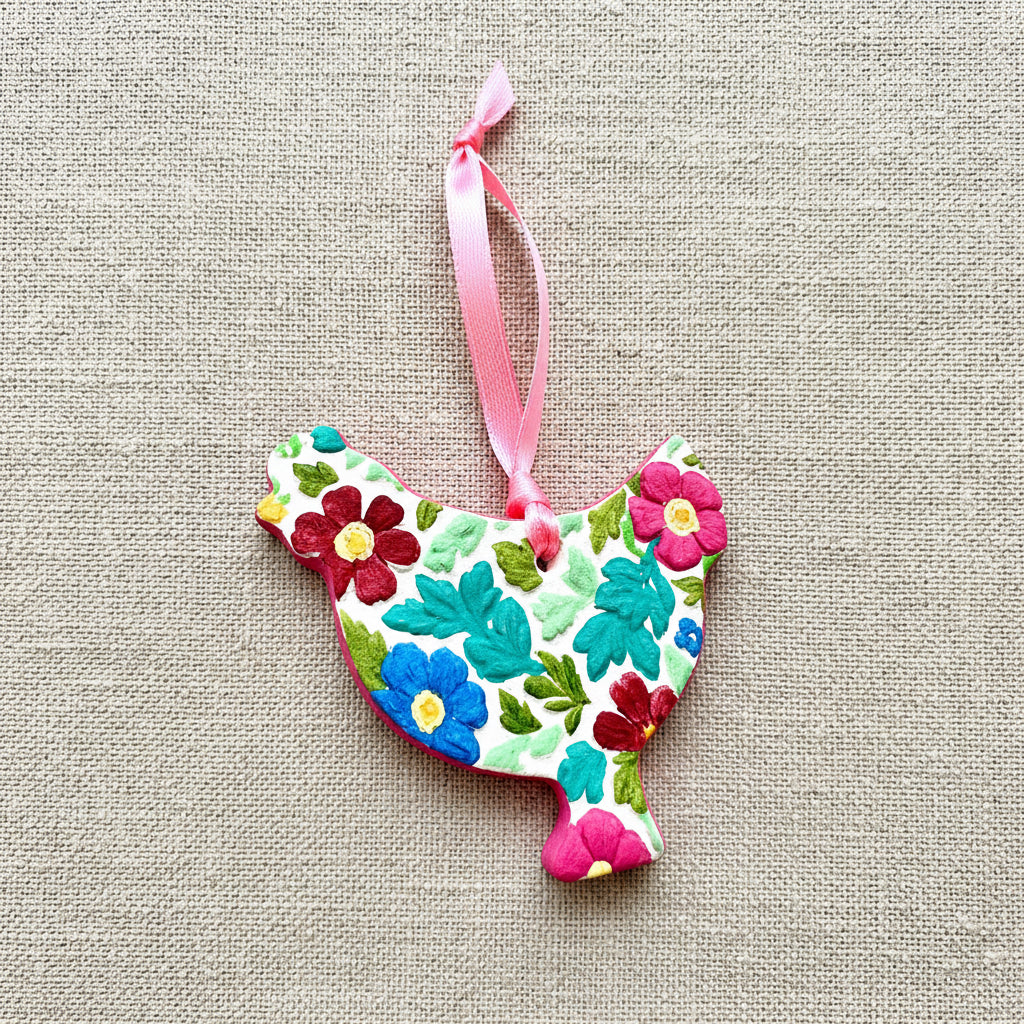 Decorative floral-patterned chicken ornament with a pink ribbon on a white background