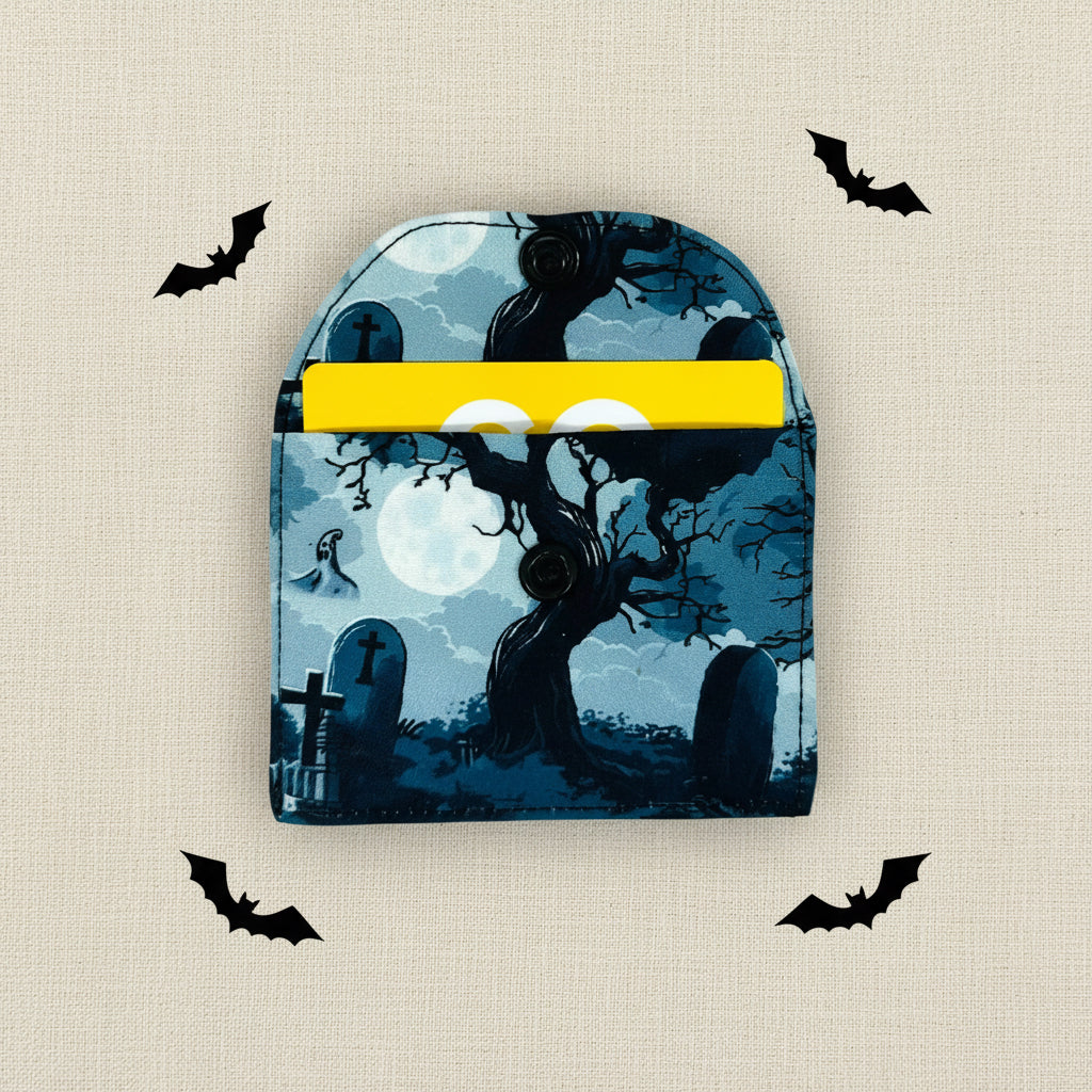 Halloween-themed card wallet with a ghost, moon, and tree design on a blue/black background.