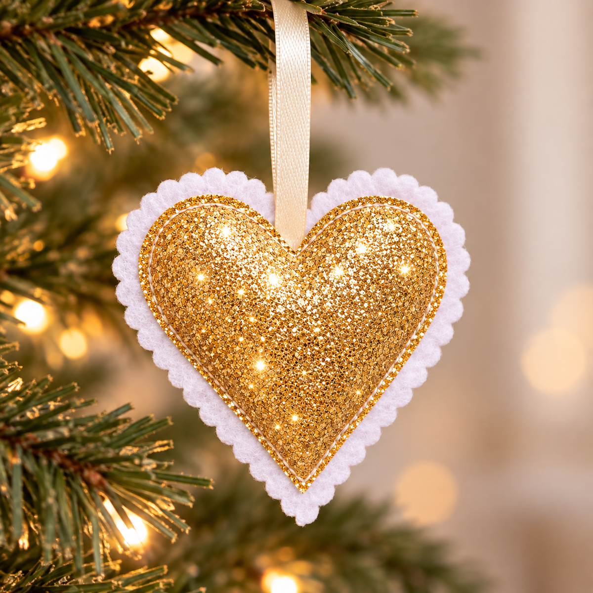 Handmade gold glitter Christmas heart decoration with scalloped felt edging and neutral-toned hanging ribbon