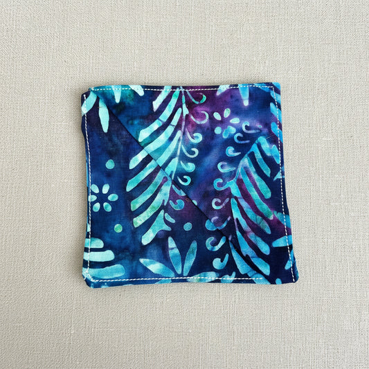 Blue and purple patterned fabric square corner bookmark on a neutral background