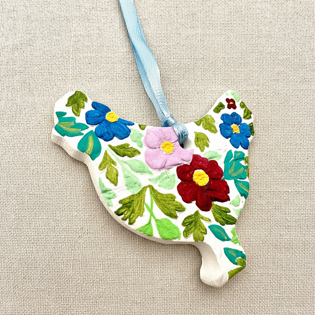 Decorative chicken shaped ornament with floral patterns on a white background