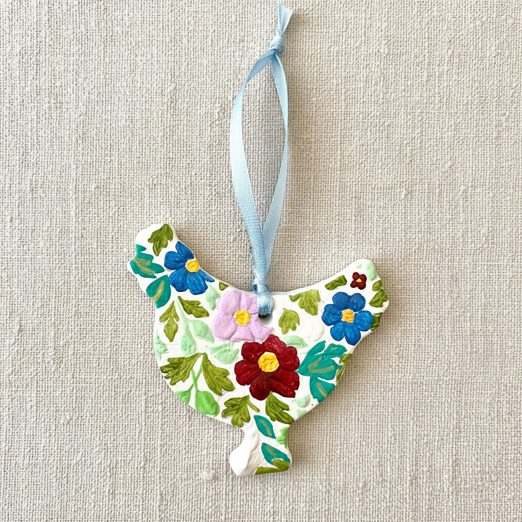 Decorative ornament shaped like a chicken with floral patterns on a white background