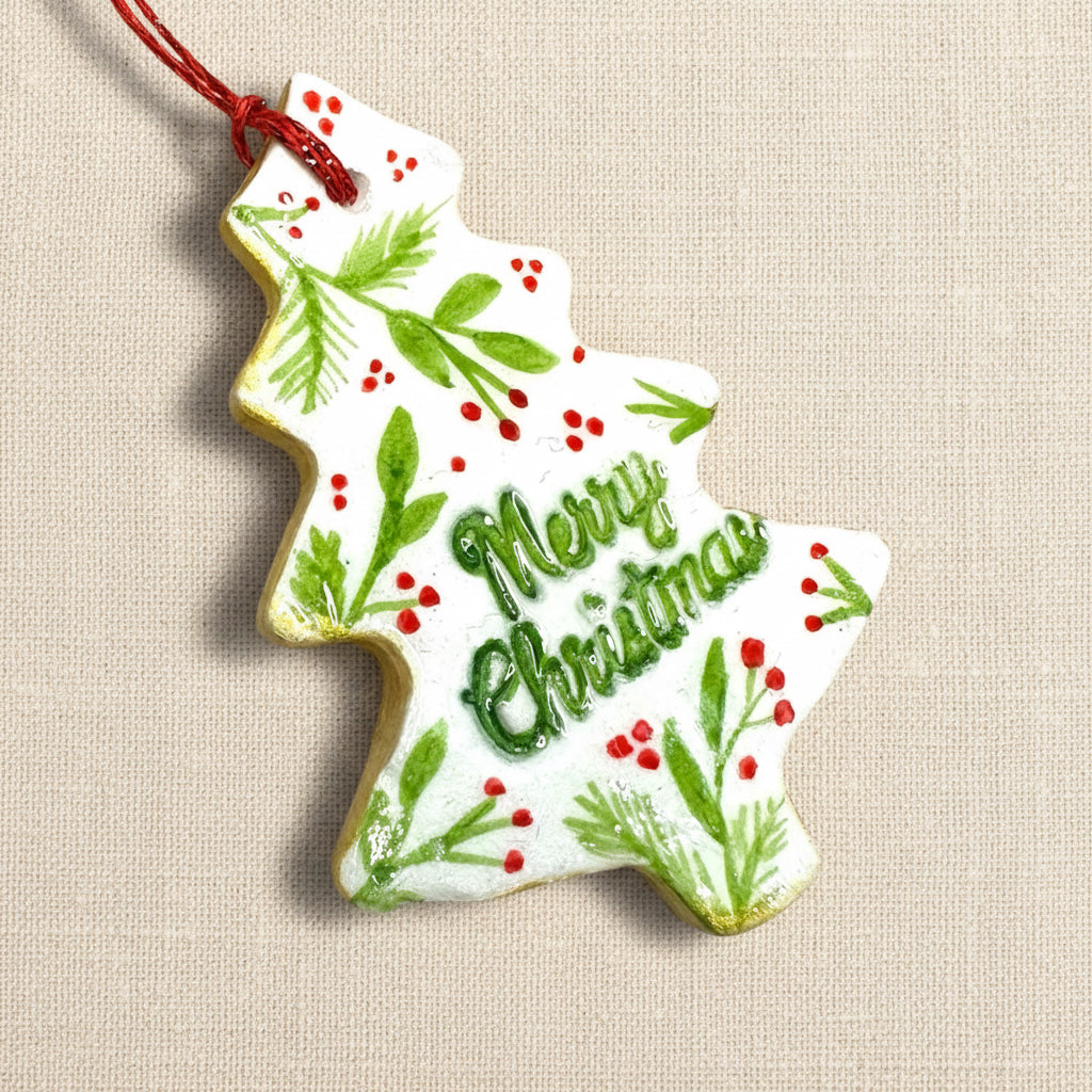 Christmas tree-shaped ornament with 'Merry Christmas' text on a light background