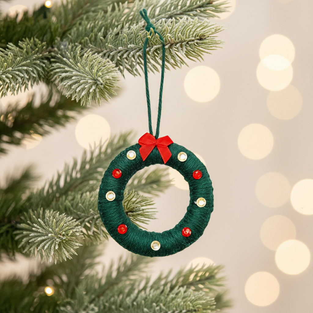 Green Christmas wreath ornament with red bow and gems on a light green background