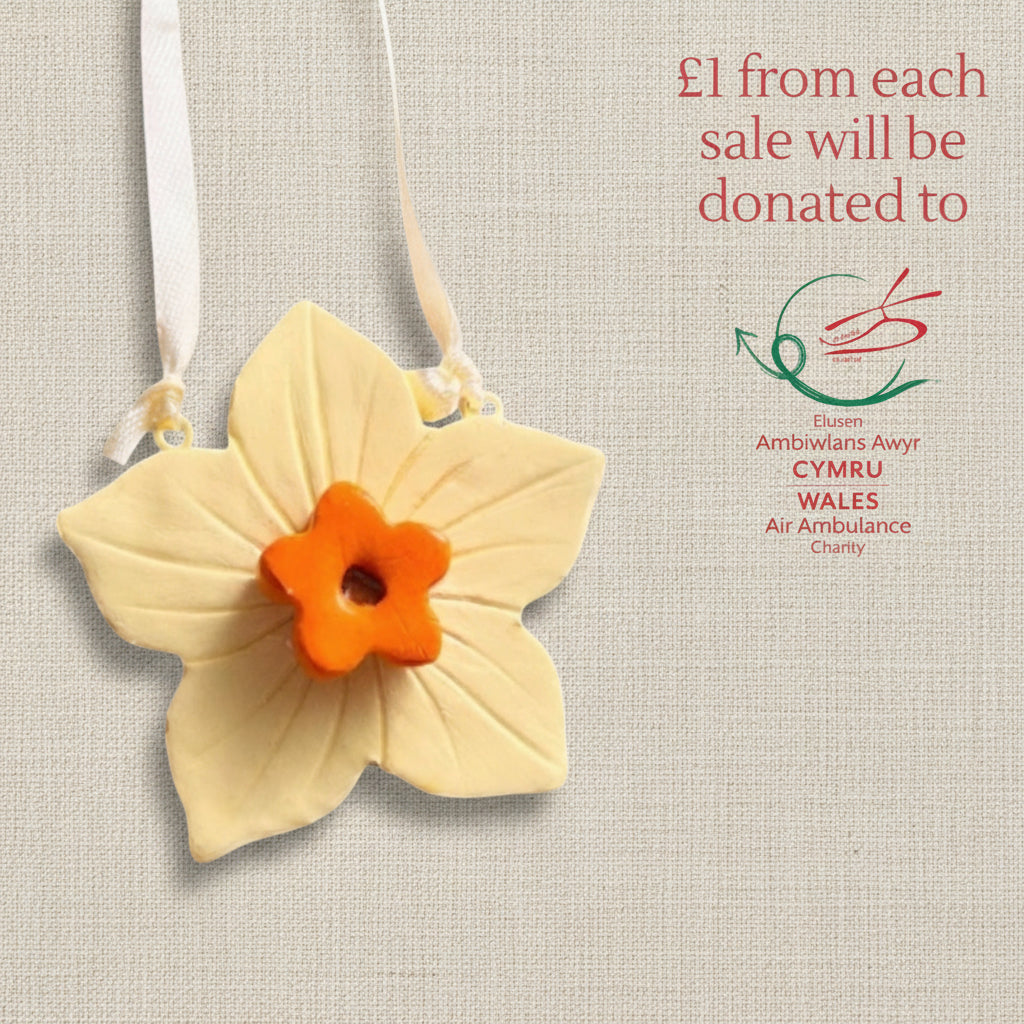 Clay daffodil ornament with ribbon to hang. Yellow flower with an orange centre.