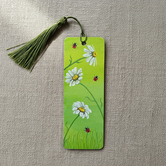 Green bookmark with floral design and ladybugs. And green tassel.
