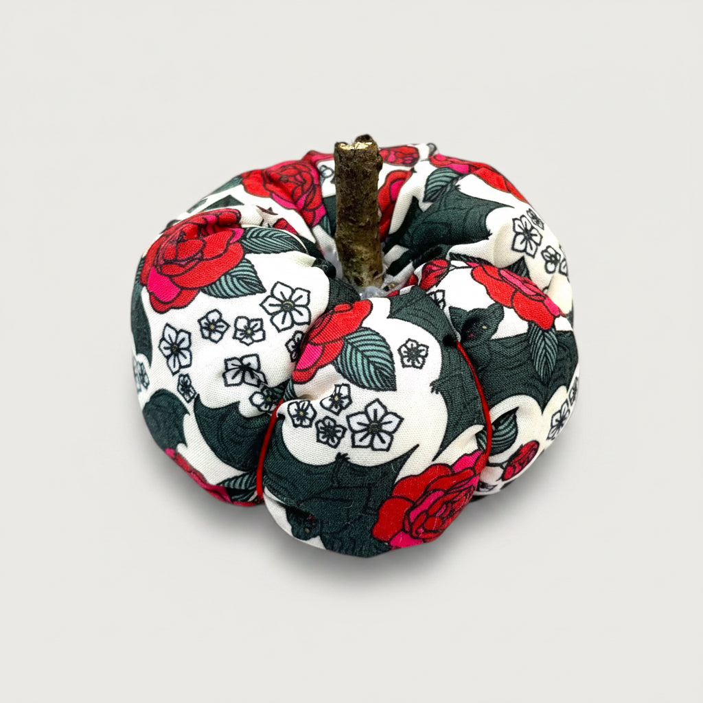 Decorative fabric pumpkin with floral and bat pattern on a white background