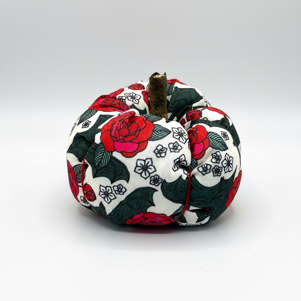 Decorative fabric pumpkin with floral and bat patterns on a white background