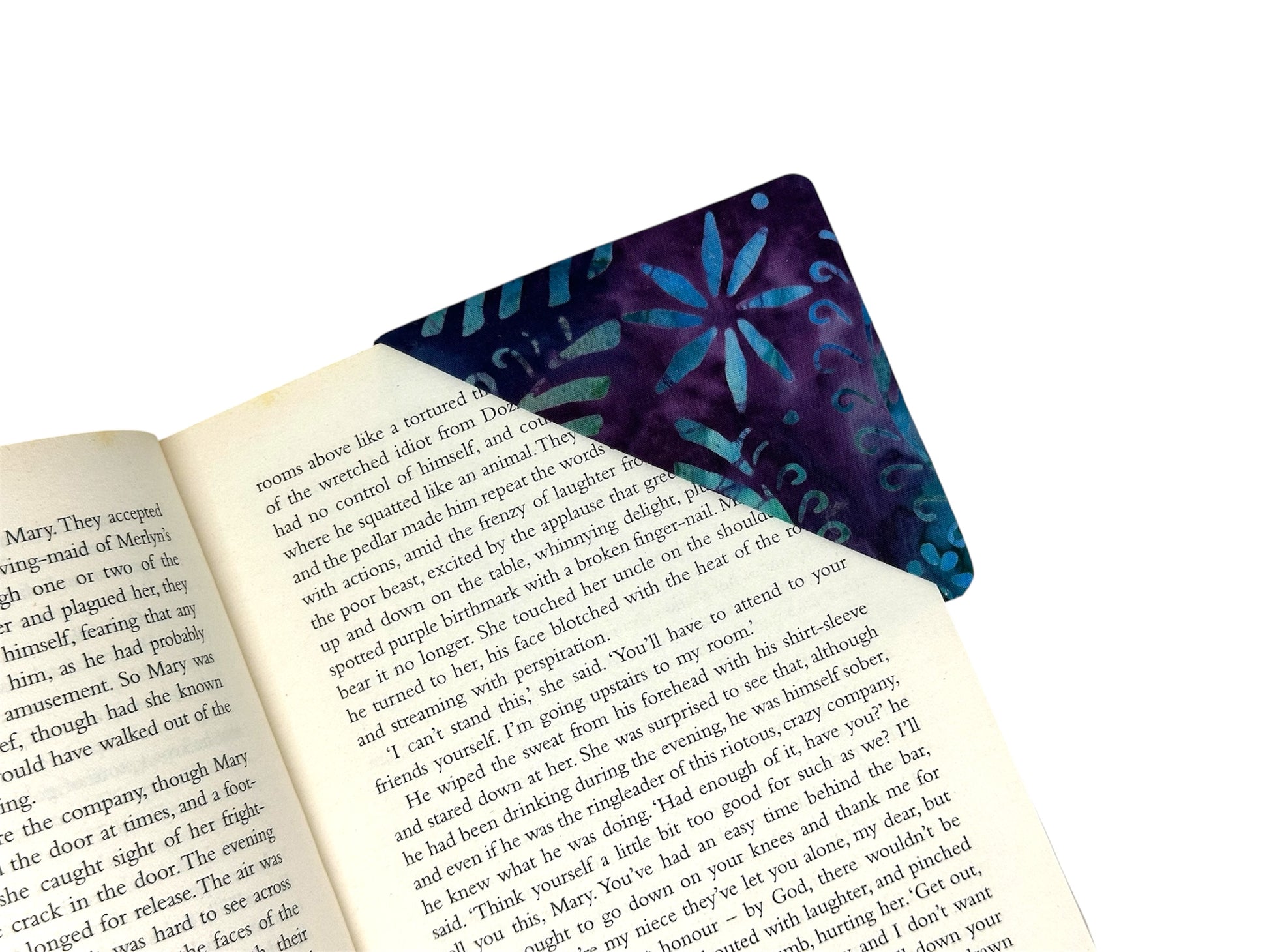 Floral-patterned fabric corner bookmark on an open book
