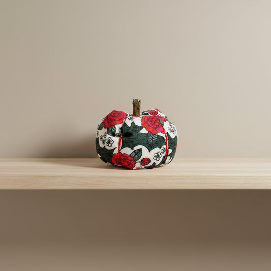 Decorative fabric pumpkin with black bat and red rose pattern on a white background