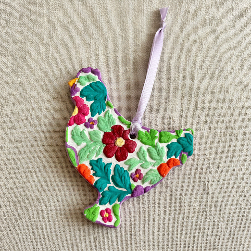 Floral-patterned clay chicken with light purple ribbon to hang