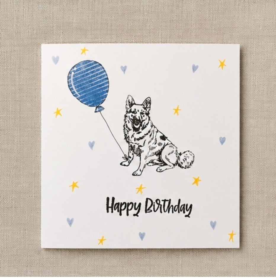 Birthday card with a German shepherd dog and blue balloon on a textured beige background