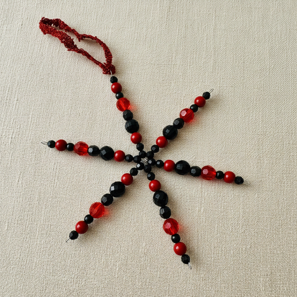 Red and black beaded snowflake decoration with red ribbon 