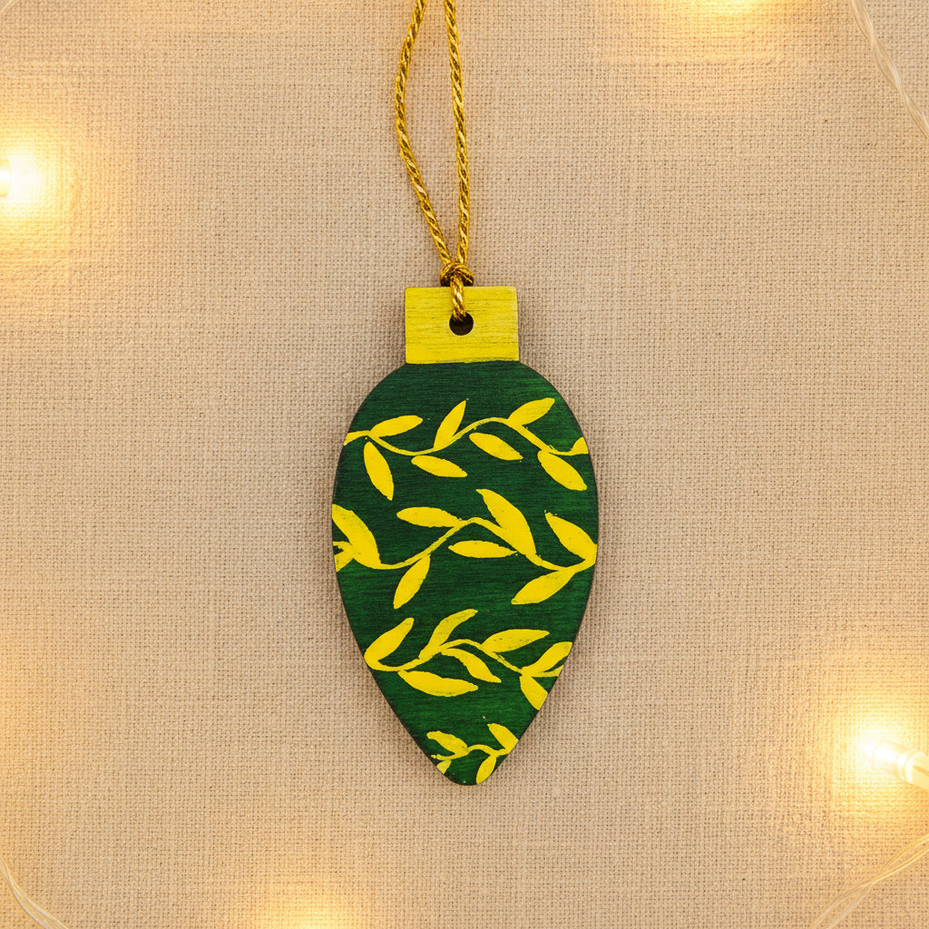 Decorative green and gold Christmas tree ornament on a neutral background