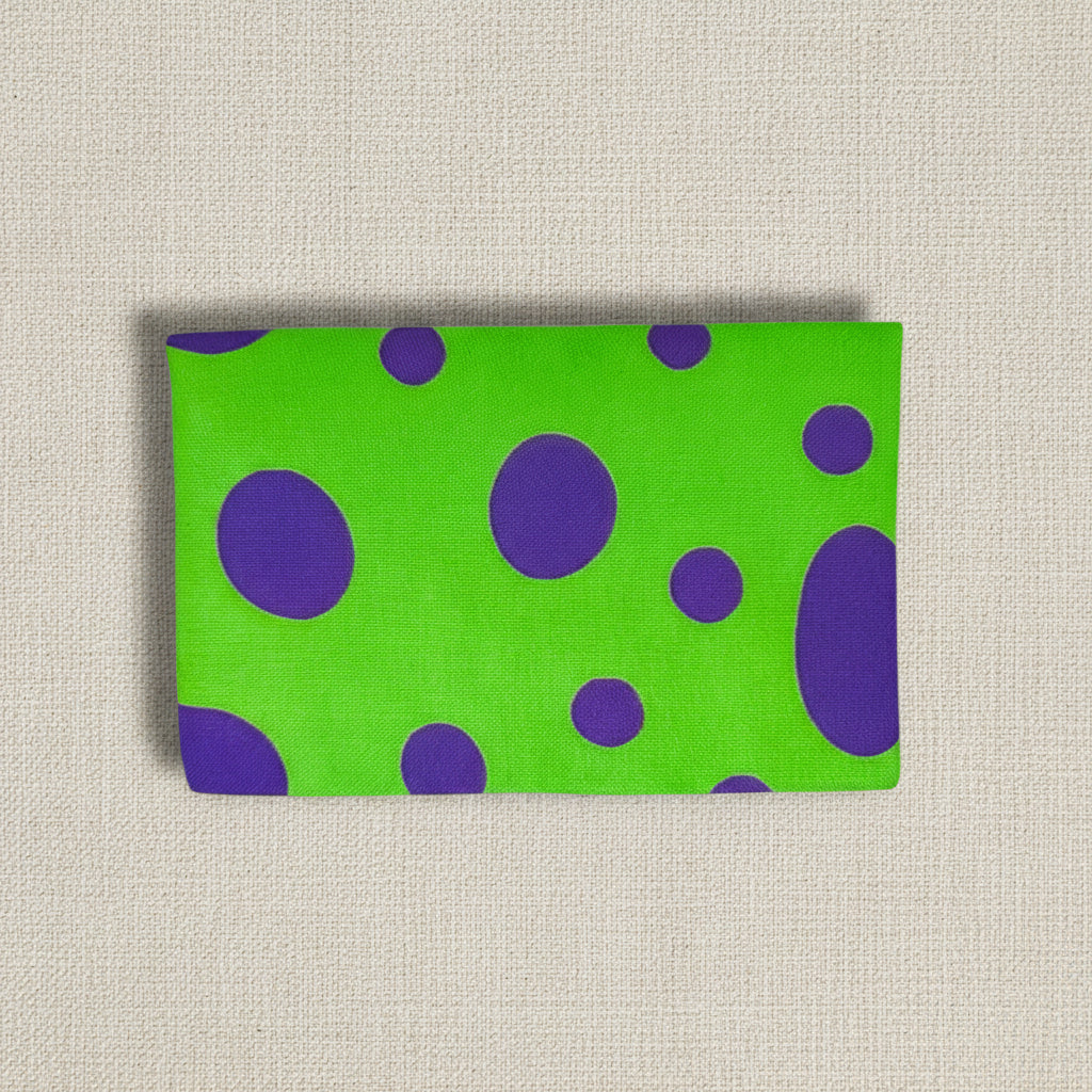 Shows back of the card wallet, green fabric with different size purple dots