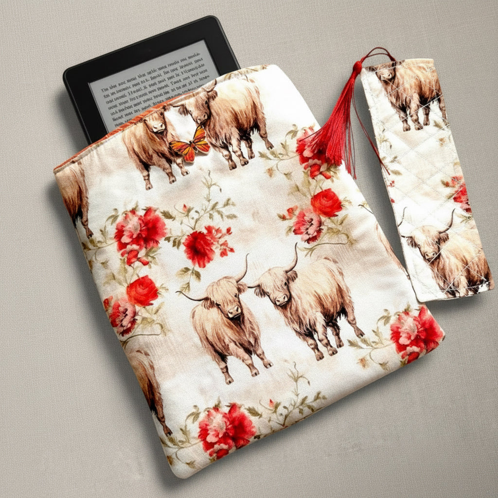 Fabric pouch with highland cattle and floral design on a neutral background, shown with kindle in the opening. Matching bookmark to the right