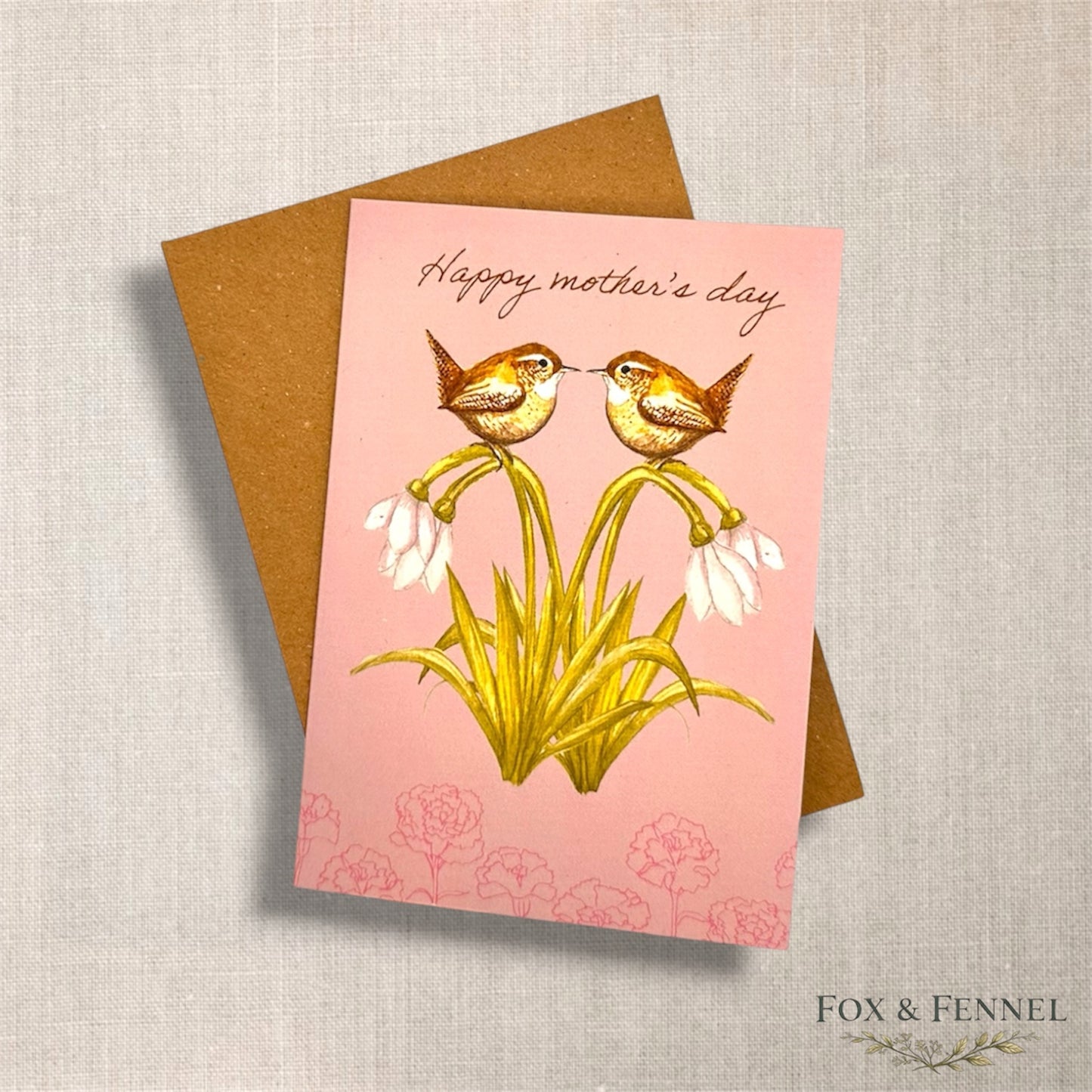 Greeting card with two British wren birds on snowdrop flowers and 'Happy Mother's Day' text, featuring a brown envelope 