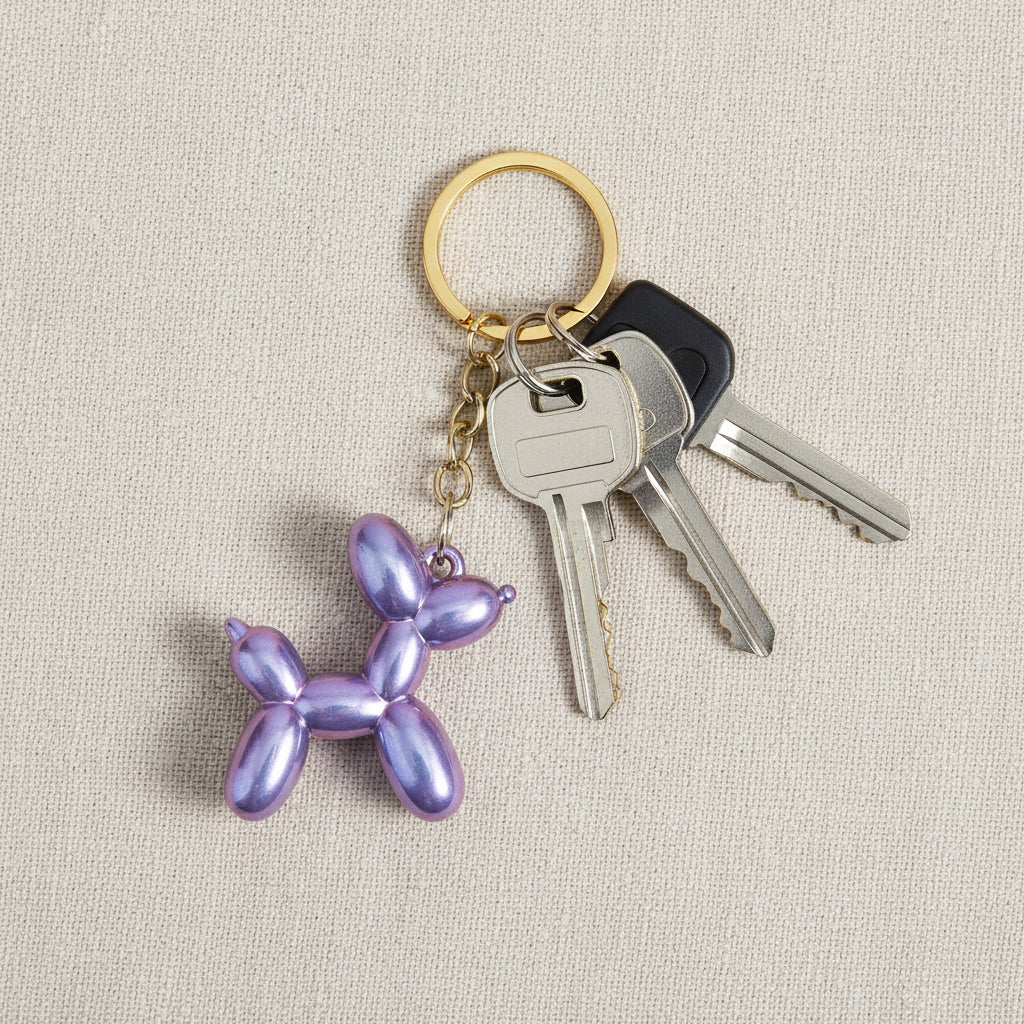 Keychain shaped like a balloon dog with iridescent purple finish on a light background