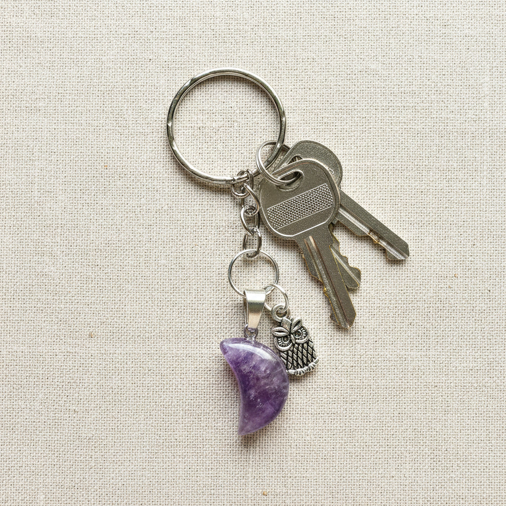 Keychain with purple crescent moon and owl charm on a white background