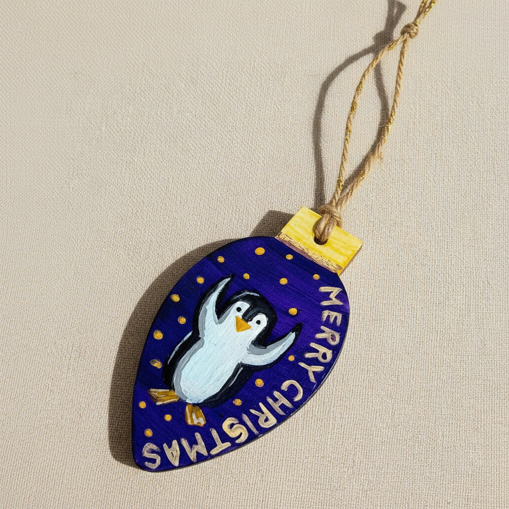 Decorative Christmas ornament with a penguin design on a blue-purple background.