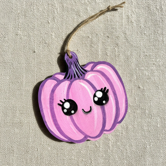 Pink pumpkin decoration with black eyes and a smile 