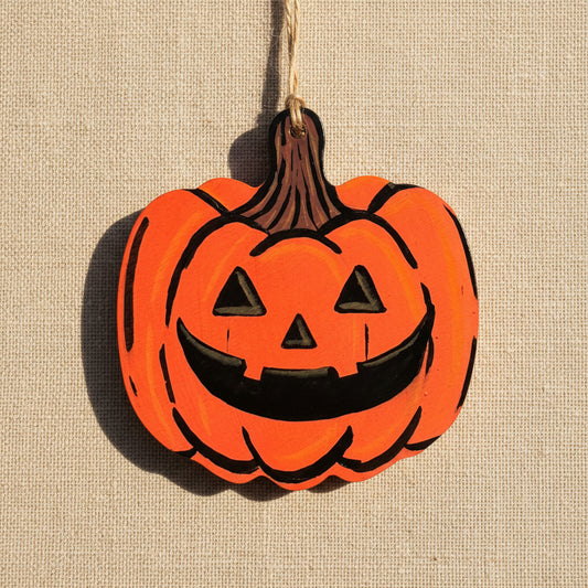 Pumpkin-shaped Halloween wooden ornament with a carved style painted face