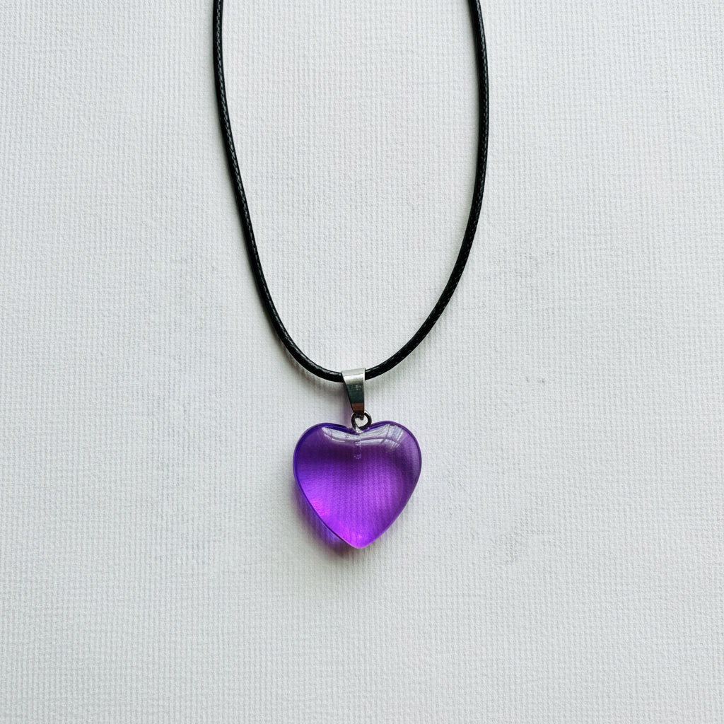 Purple heart-shaped pendant on a black cord against a white background