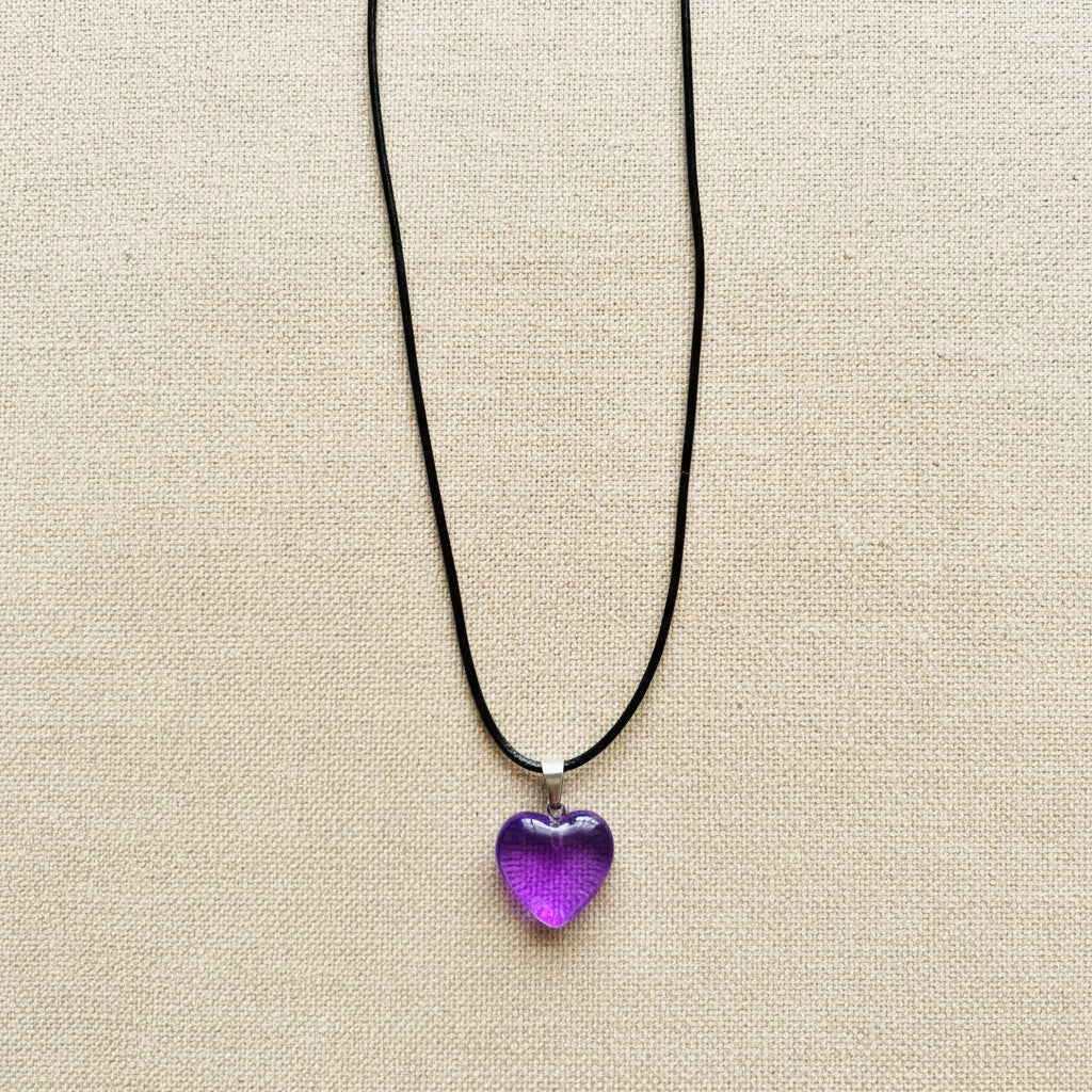 Necklace with a purple heart-shaped pendant on a neutral background