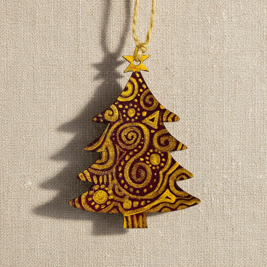 Decorative wooden Christmas tree shaped ornament with gold patterns on a dark red background