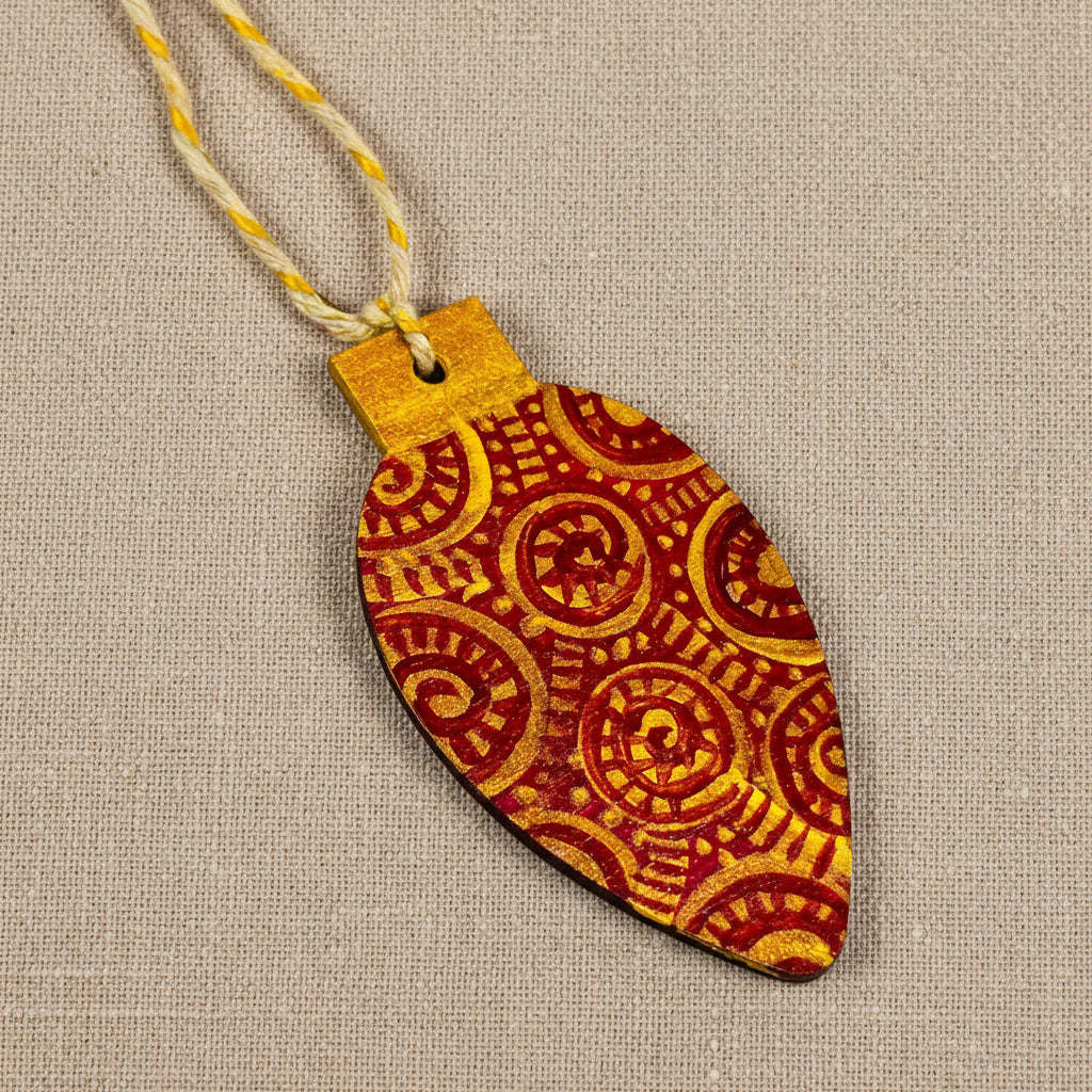 Decorative wooden chrome tree ornament with red and gold patterns on a neutral background