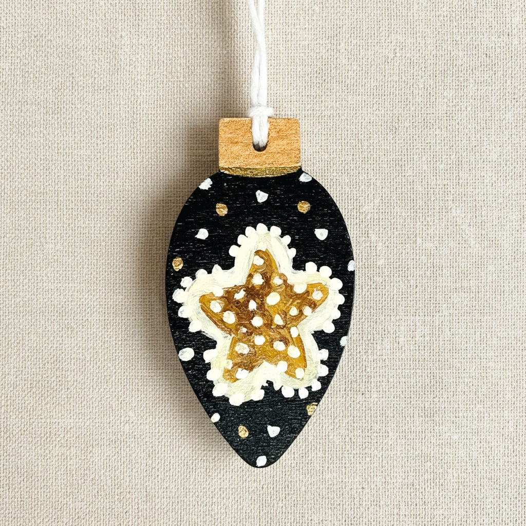 Decorative Christmas tree ornament with a starfish design on a black background, hanging from a string.