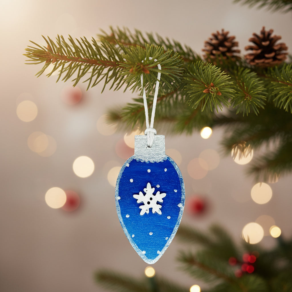 Blue Christmas light bulb shaped ornament with a white wooden snowflake