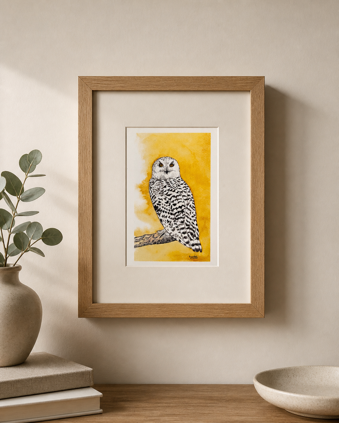 Framed artwork of an owl on a yellow background in a home setting.