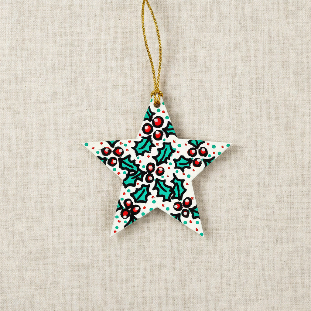 Star-shaped Christmas ornament with holly design on a white background