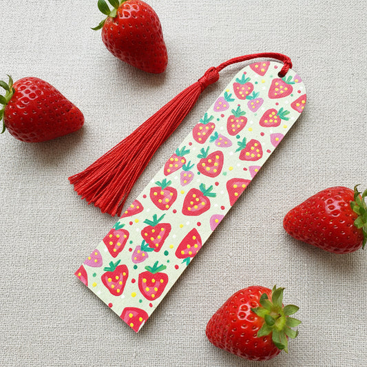Wooden Bookmark with strawberry pattern and red tassel on a linen background 