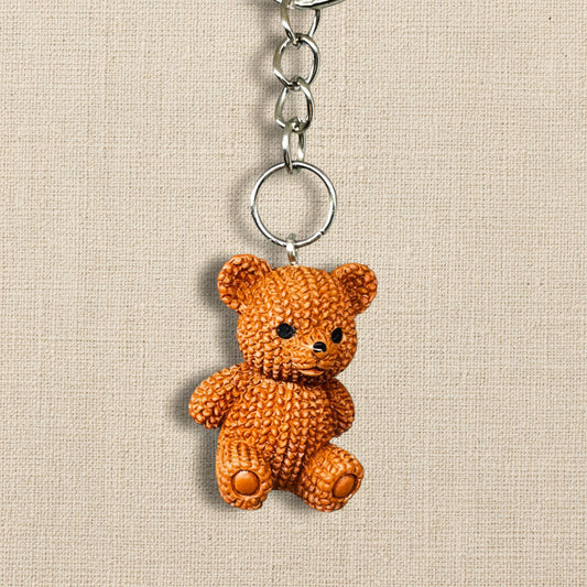 Brown teddy bear keychain on a light neutral background