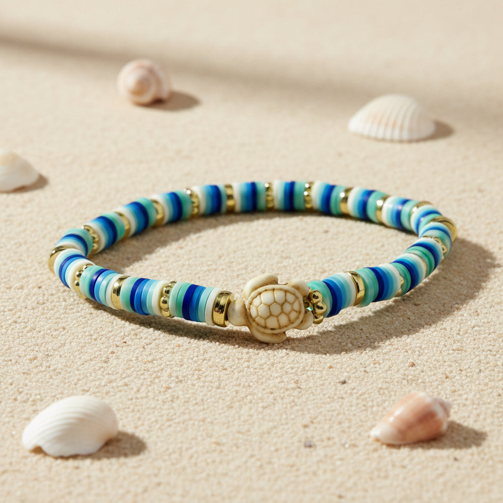 Multicoloured beaded bracelet with turtle charm on a sandy background 