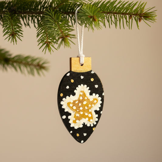 Decorative ornament with a starfish design on a black background, hanging against a neutral background.