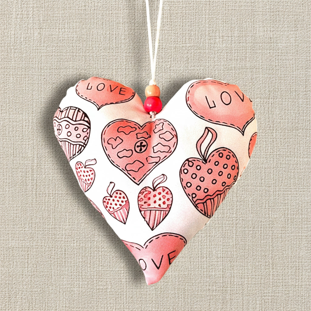 Heart-shaped decorative fabric hanging item with various heart designs and 'LOVE' text, pink hearts on white background 