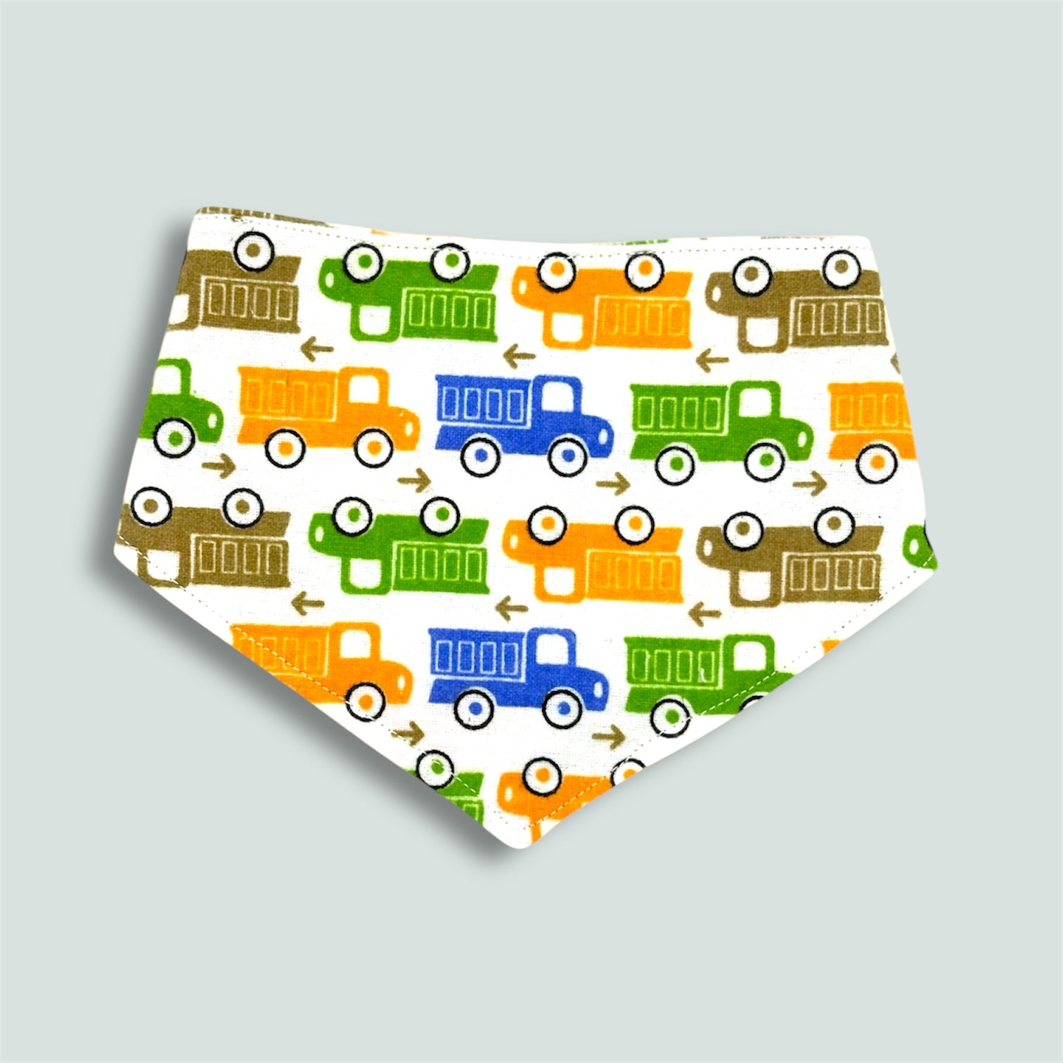 Baby bib with colourful truck pattern on a light gray background
