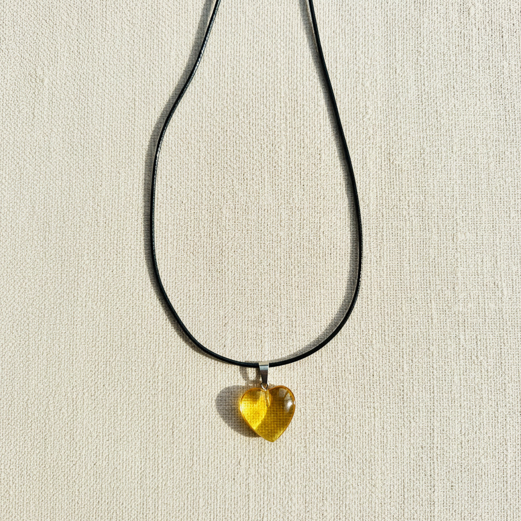 Necklace with a yellow heart-shaped pendant on a neutral background