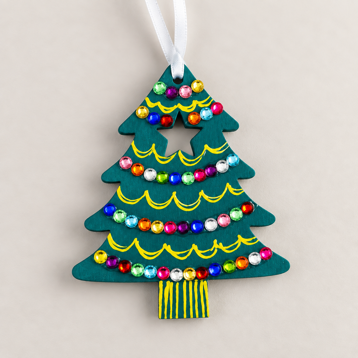 Hand-painted teal wooden Christmas tree decoration with colourful gem embellishments, yellow painted details and a white hanging ribbon