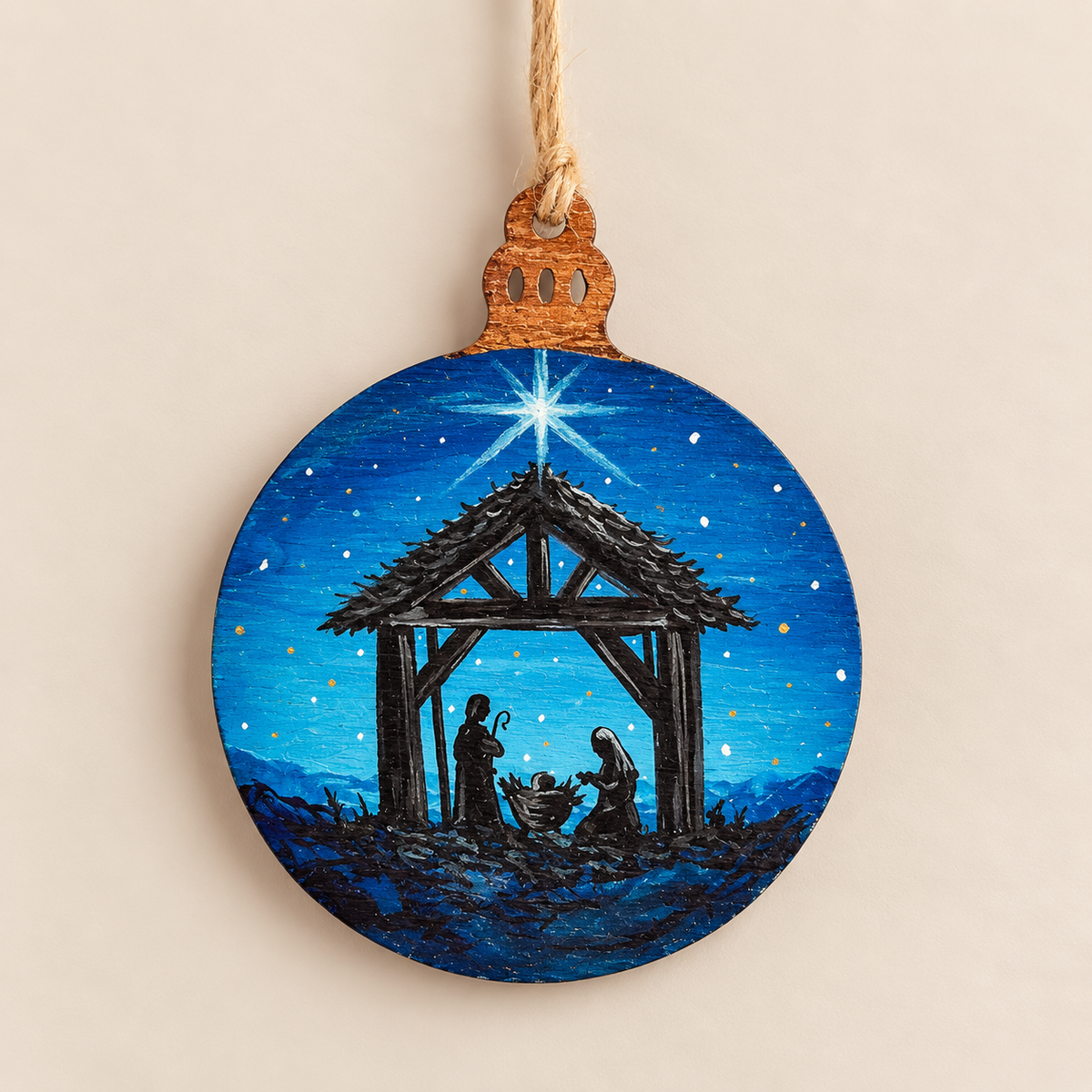 Hand painted wooden Christmas ornament featuring a nativity scene under a starry blue night sky.