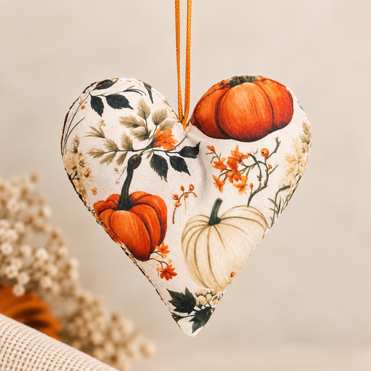Handmade cream fabric heart hanging decoration featuring orange pumpkins, autumn leaves and botanical details.