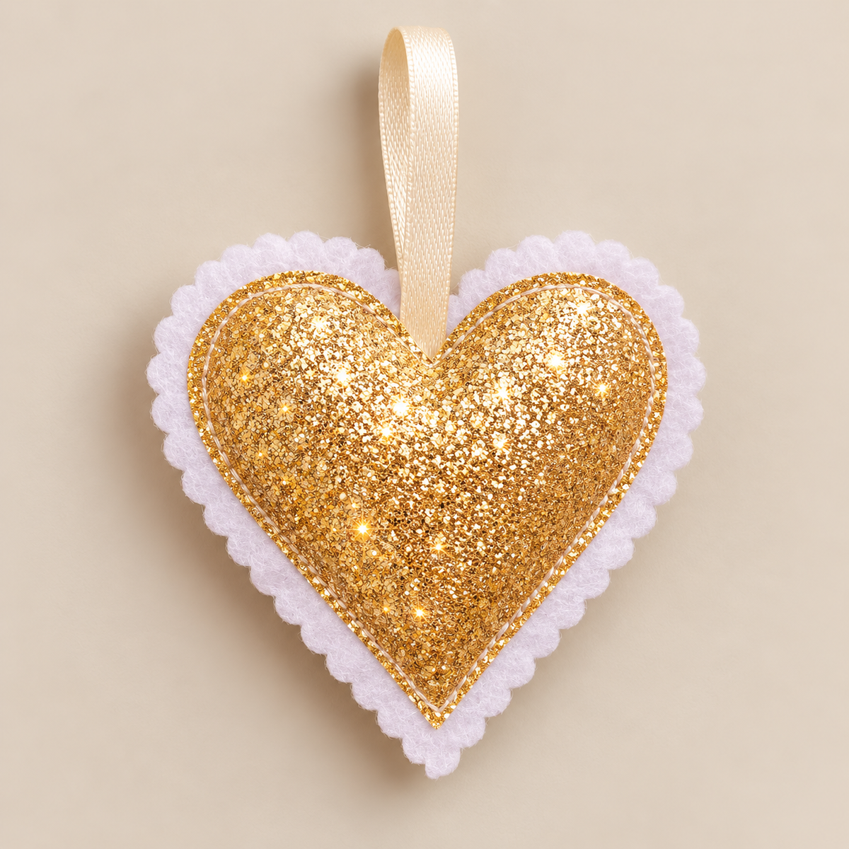 Handmade gold glitter Christmas heart decoration with scalloped felt edging and neutral-toned hanging ribbon