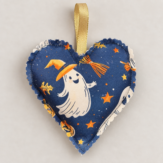 Handmade navy blue Halloween fabric heart decoration featuring a white ghost wearing an orange witch hat, with stars and a gold hanging loop