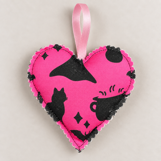 Handmade bright pink Halloween fabric heart with black witch hat, cat, cauldron, stars and bat motifs, finished with a pink hanging ribbon