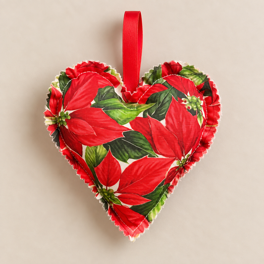 Handmade red poinsettia fabric heart decoration with green leaves and a red satin hanging loop.