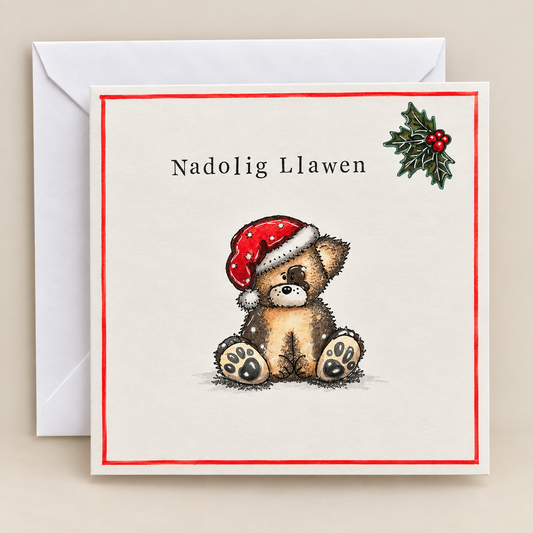 Handmade Welsh Christmas card featuring a teddy bear wearing a Santa hat, with Nadolig Llawen greeting and holly detail.