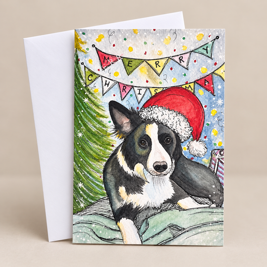 Festive Christmas card featuring a black and white border collie dog wearing a red Santa hat, beside a Christmas tree and colourful bunting, with a white envelope